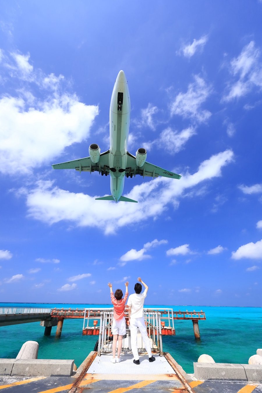 空港デッキで飛行機を見上げる